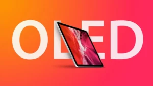 Tablet nakloněný před velkým nápisem OLED na oranžovo-růžovém pozadí