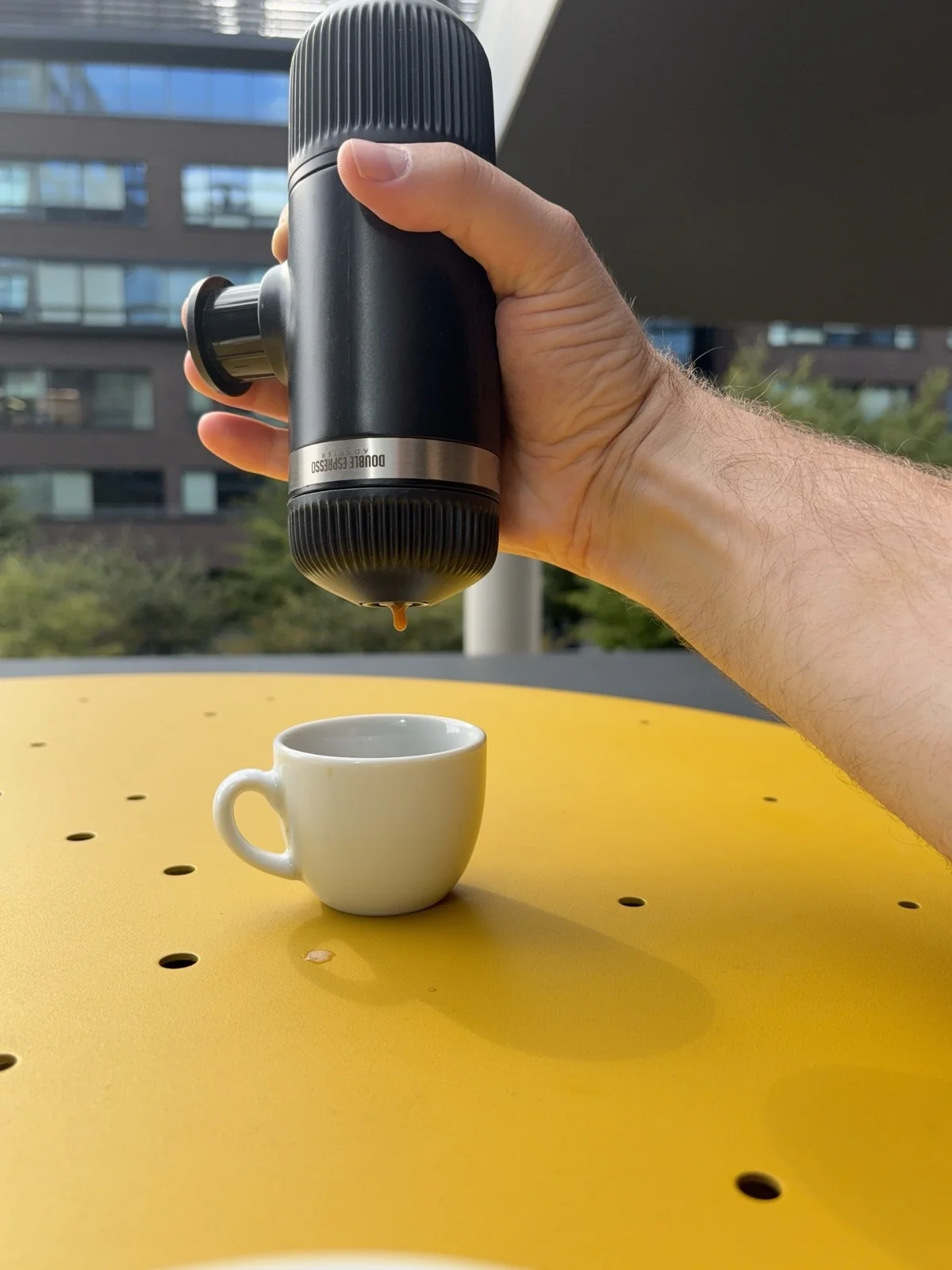 Espresso kape z kávovaru Wacaco Nanopresso drženého v ruce do šálku