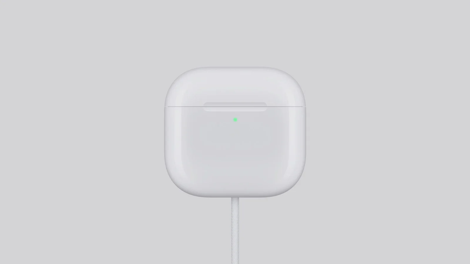 Bílá bezdrátová sluchátka AirPods 5 vedle otevřeného nabíjecího pouzdra na světlém pozadí