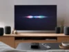 Nová Apple TV 4K má dostat Siri AI: kód tvOS 27.2 ukazuje chytré odpovědi Apple TV 4K s ovladačem Siri Remote u televize, kolem čtyři reproduktory HomePod