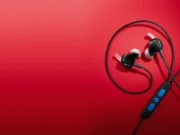 Bose vrací drátová sluchátka: s USB-C a potlačením hluku bez baterie Černá drátová sluchátka Bose s kabelem a ovladačem s modrými tlačítky na červeném pozadí