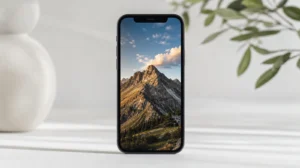 iPhone s iOS 27 a zamknutou obrazovkou s malými hodinami v horní řadě a fotkou přes celý displej
