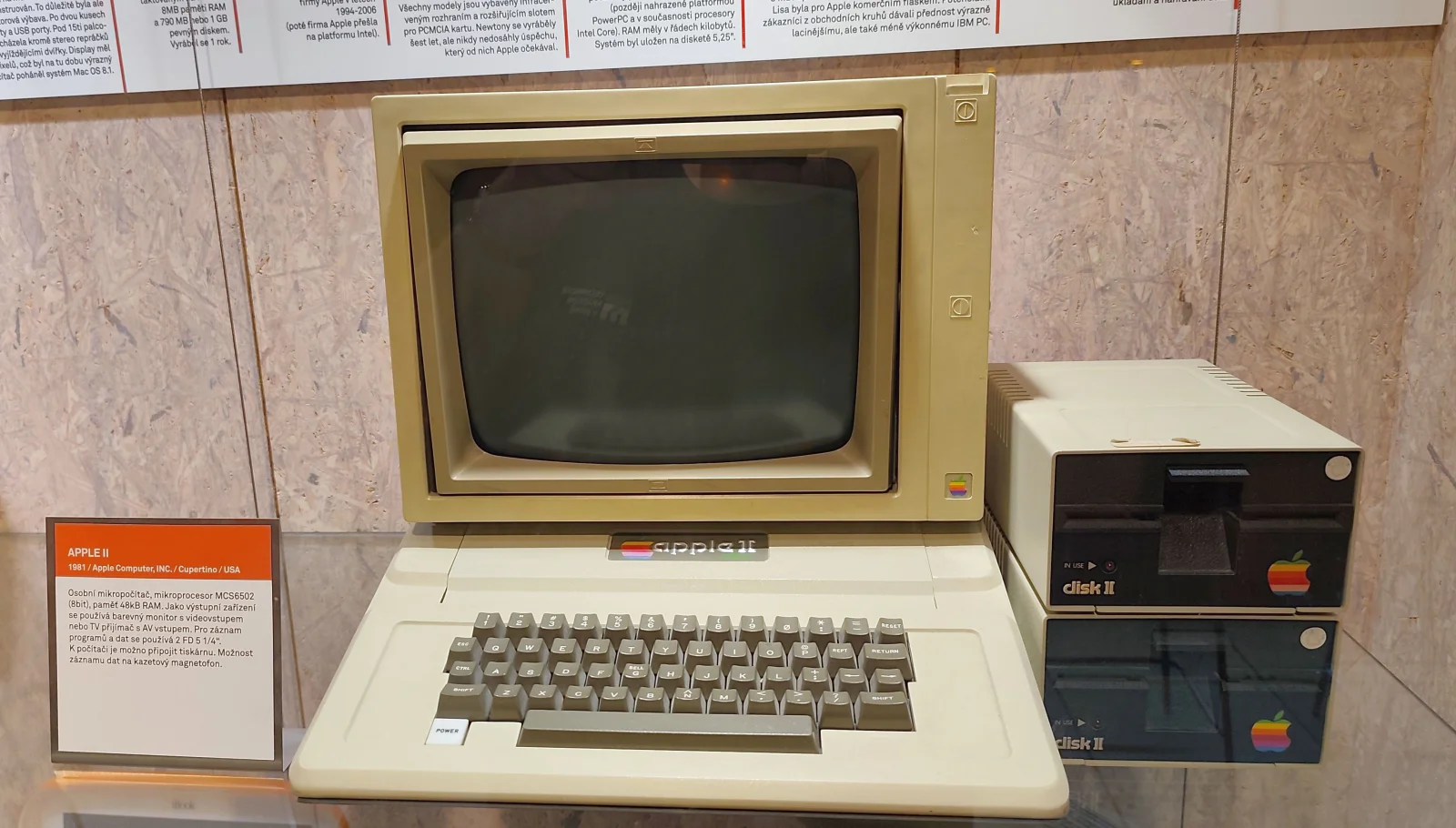 Béžový počítač Apple II s monitorem a dvěma disketovými mechanikami Disk II ve vitríně muzea